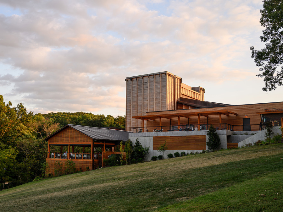 The Filene Center and Meadow Commons, angular wooden buildings, on a grassy hill surrounded by trees.